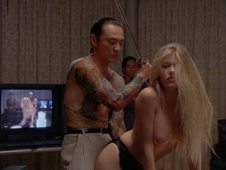 Cary-Hiroyuki Tagawa pointing the sword at Renee Allman in a movie scene from the 1991 film Showdown in Little Tokyo