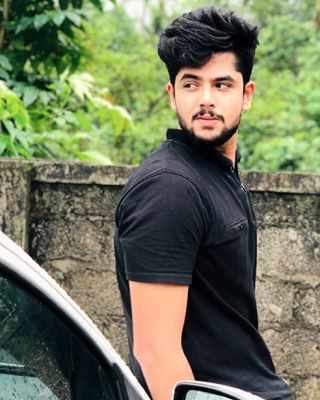 Sidharth Prabhu with beard and mustache while wearing black polo shirt