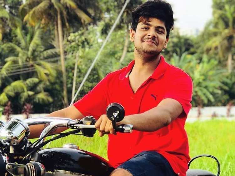 Sidharth Prabhu riding on a motorcycle while wearing red polo shirt