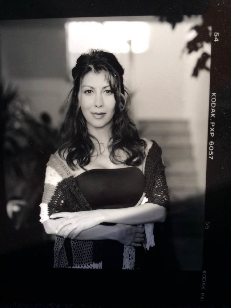 Sigal Erez smiling while her arms crossed and wearing a sleeveless blouse and shawl