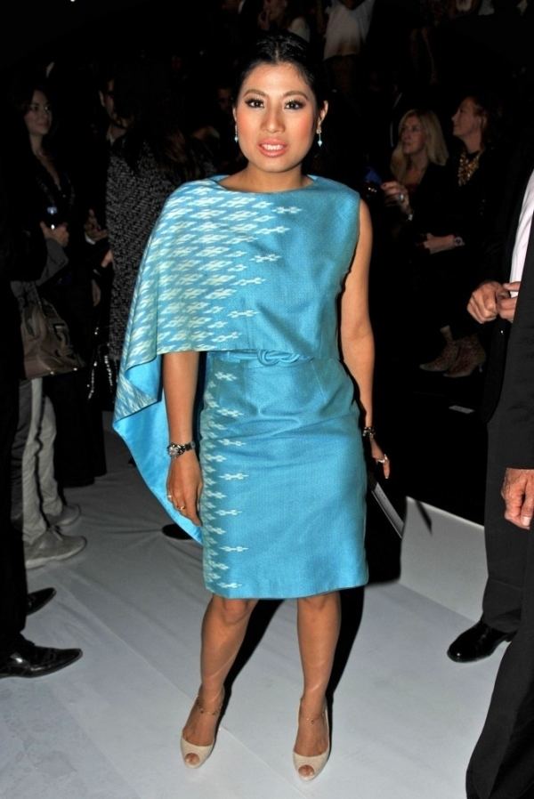 Sirivannavari Nariratana smiling while at the Tuileries Garden during Paris Fashion Week and wearing a white and sky-blue dress