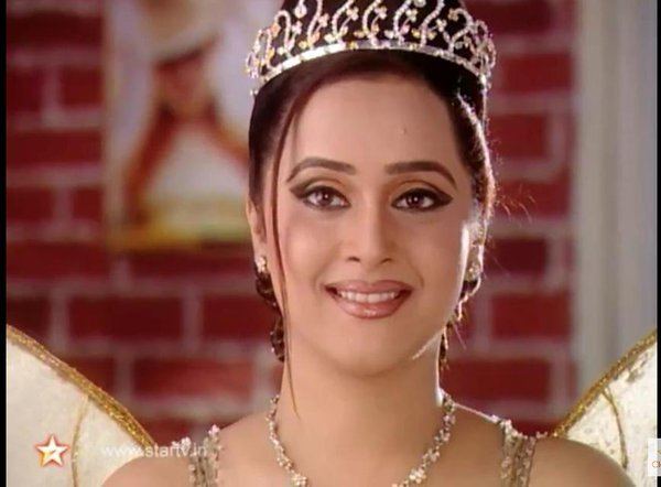 Mrinal Kulkarni as Son Pari smiling, wearing a crown, earrings, a necklace, a yellow sleeveless top, and a yellow fairy wing in a scene from Son Pari, a 2000 Indian children's fantasy-adventure television series.