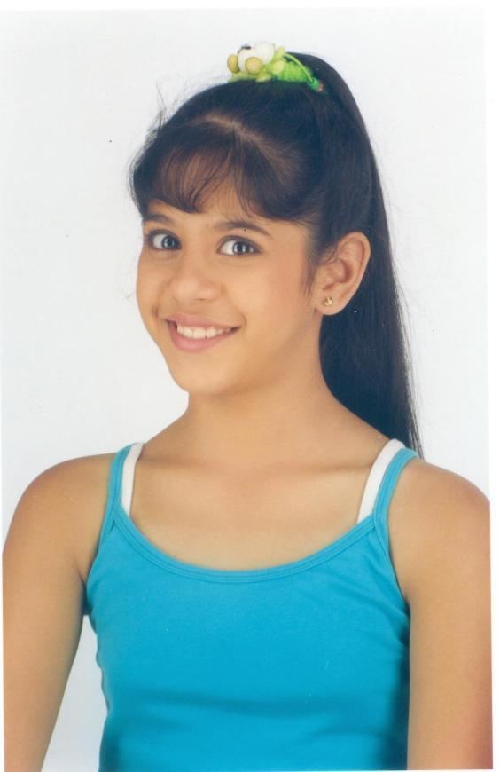 Young Tanvi Hegde as Frooty in Son Pari, with a big smile on her face, with a ponytail hair, and wearing a blue sleeveless top with white strap.