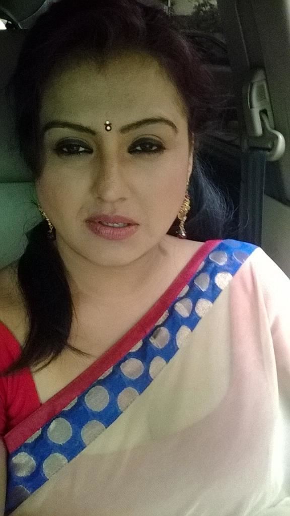 Sona Heiden riding in the car while wearing a red dress, white and blue duppata, and earrings