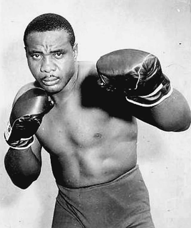 Sonny Liston wearing boxing gloves and short