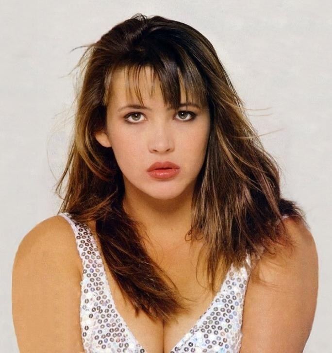Sophie Marceau looking fierce with her hair down and wearing a white dotted sleeveless showing her cleavage