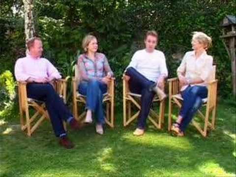 Jonathan Scott as Edmund, Sophie Wilcox as Lucy, Richard Dempsey as Peter, and Sophie Cook as Susan, cast members of the BBC Chronicles of Narnia series, are smiling and sitting during an interview (from left to right) with trees and leaves in their background. Jonathan with blonde hair wearing pink long sleeves, jeans, blue socks, and shoes. Sophie with blonde short hair wearing blue, pink, and purple long sleeves, pants, and pointed shoes. Richard with a neat hairstyle wearing a white long-sleeved shirt and jeans. Sophie with blonde hair in a ponytail wearing a long polo shirt and jeans.