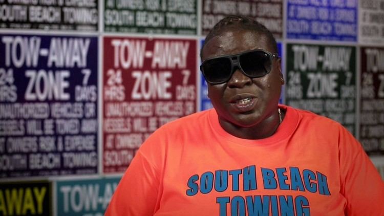 Lakatriona "Bernice" Brunson wearing black shades and an orange and blue t-shirt