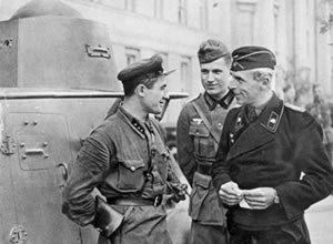 Soviet and German officials are having a friendly conversation in the newly captured Polish city of Brest in September 1939. All are wearing army uniforms.