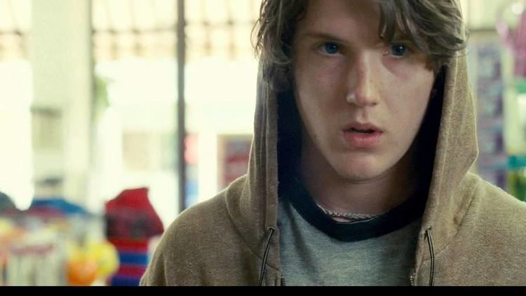 Spencer Treat Clark wearing a brown jacket and gray t-shirt in a scene from the 2009 film, The Last House on the Left