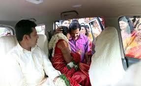 Sreekandan Nair hugging a woman who is sitting inside the car