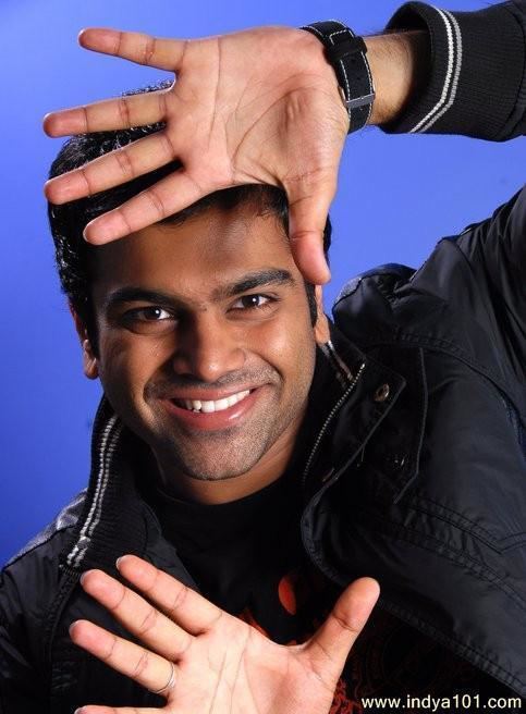 Sreerama Chandra Mynampati smiling and posing funnily while wearing a black jacket with a black shirt underneath.