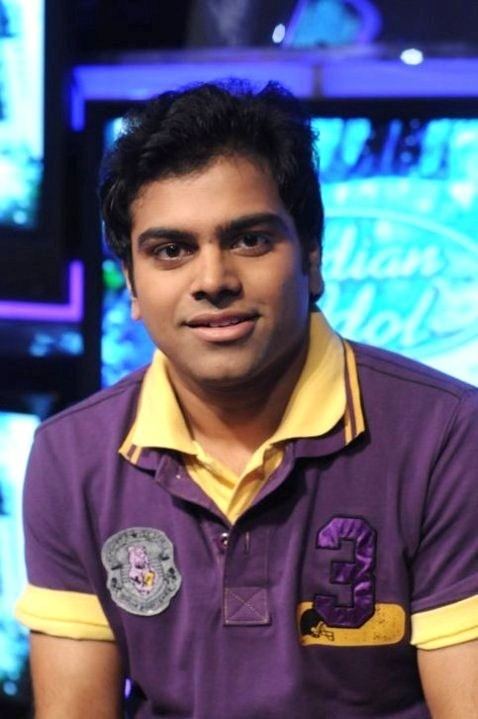 Sreerama Chandra Mynampati smiling on the set of Indian Idol and wearing a yellow polo shirt with yellow collar.