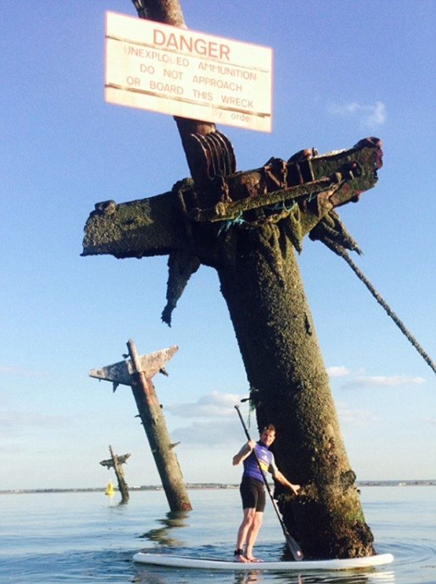 SS Richard Montgomery Shane Skinner poses next to stranded WWII ship laden with unexploded