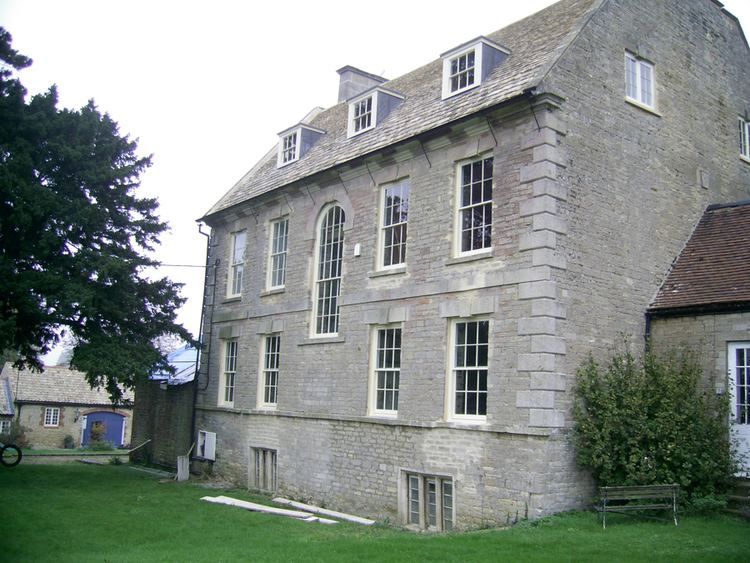 A side portion of Stanwick Hall in Northamptonshire that shows a lawn.
