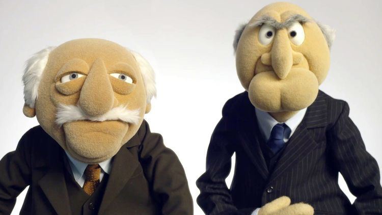 Statler wearing a brown suit and Waldorf wearing a black suit.