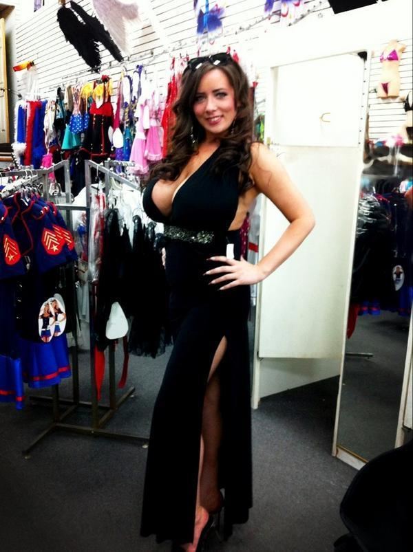 Stephanie Fox posing inside a department store and wearing a black sleeveless dress.