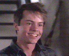 Stephen Geoffreys smiling while wearing a black long sleeves