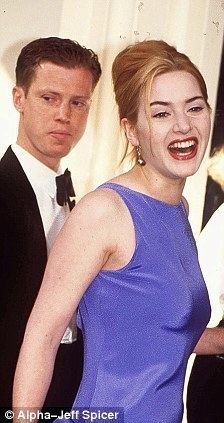 Stephen Tredre wearing formal attire with Kate Winslet in a blue gown