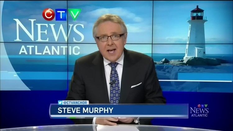 Steve Murphy performing as a newscaster on CTV Atlantic Evening News and wearing a white long-sleeved white suit and blue necktie underneath a black coat.