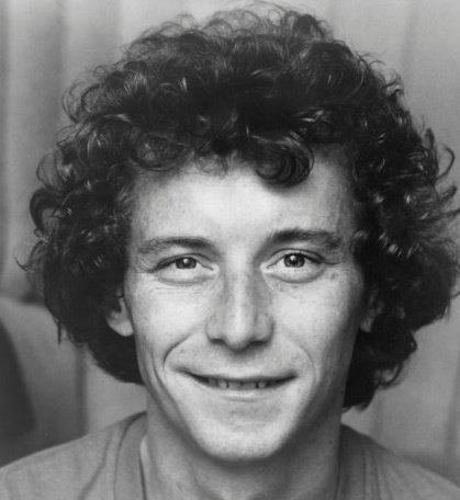 Steve Tracy smiling and with curly hair.