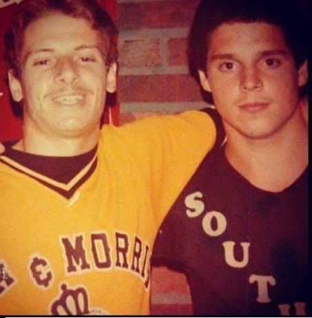 Steven Mazzone with his arm on the shoulders of Anthony Mazzone. Steven wearing a yellow jersey shirt while Anthony wearing a brown jersey shirt.