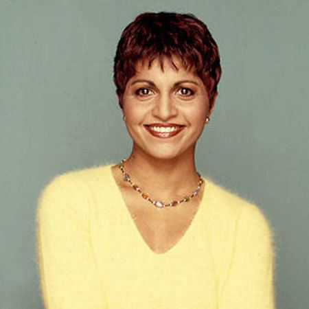 Suhana Meharchand smiling while wearing a yellow blouse and some pieces of jewelry