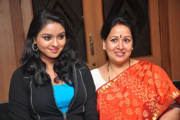 Nakshatra smiling with her mother Sumithra at the Doo Movie Press Meet while wearing a black jacket, blue inner blouse, and earrings