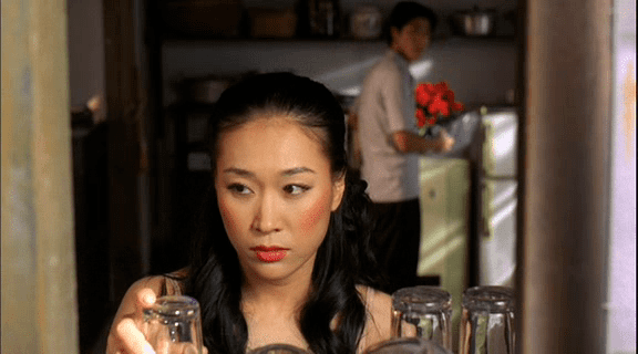 Kim Ji-Hyun holding a drinking glass in a movie scene from the 2001 film Summertime
