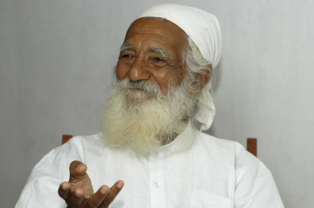 Sunderlal Bahuguna with white mustache and beard, wearing a white bandana and a white shirt.