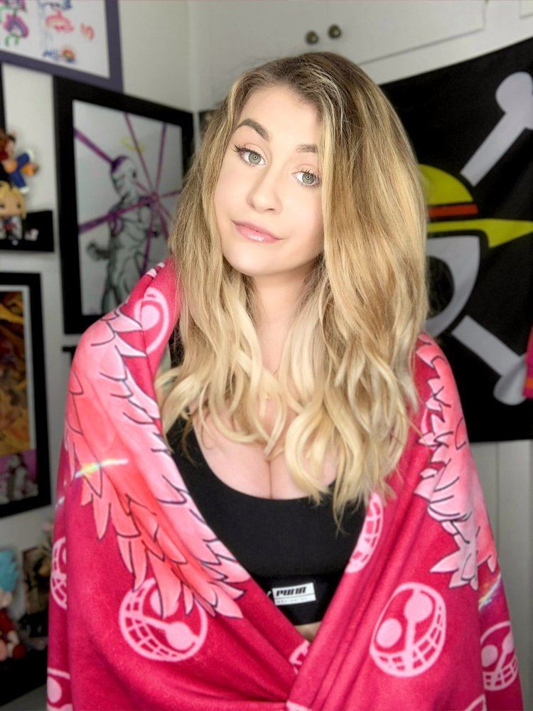 SuperMechaFrieza looking serious with her blonde hair down while wearing a black tank top and pink shawl