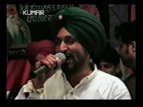 Surjit Bindrakhia singing and wearing a white sleeve and green turban