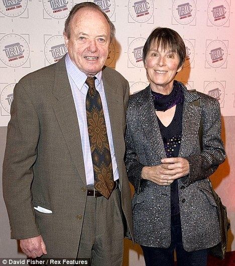 Susan Jameson in her gray and black outfit and James Bolam wearing brown coat, white long sleeves and floral neck tie