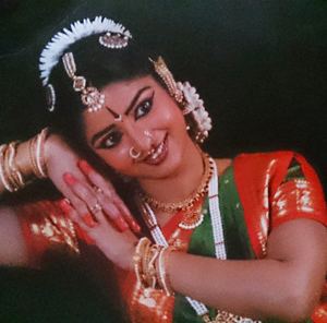 Sushma K. Rao smiling and wearing an Indian costume and accessories.