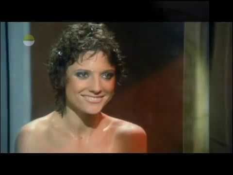 Suzanne Danielle as Emmannuelle Prevert smiling with short curly hair in a scene from the 1978 film Carry on Emmannuelle