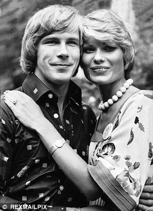 James Hunt with a tight-lipped smile while Suzy Miller's hand is on his shoulder and she is wearing a pearl necklace and floral blouse
