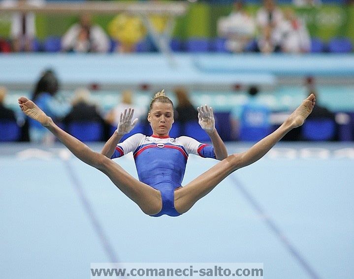 Svetlana Khorkina during her gymnast competition while wearing a white and blue bodysuit with red lining