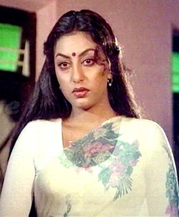 Swapna (actress) wearing a white long-sleeved shirt and earrings