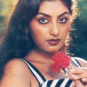 Swapna (actress) wearing a black and white striped sleeveless shirt while holding a flower