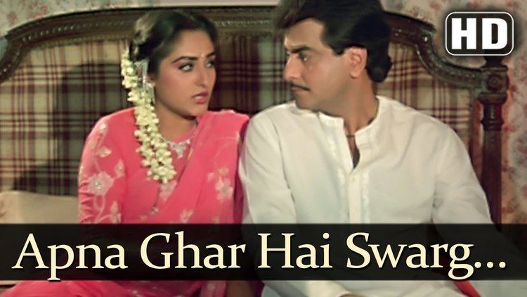 Jaya Prada and Mithun Chakraborty looking at each other while sitting on the bed in a scene from the 1986 film "Swarag se Surrender"