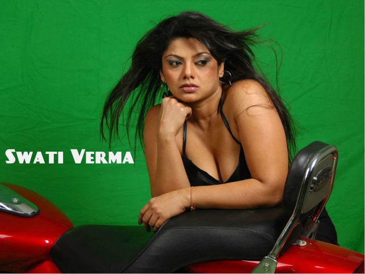 Swati Verma posing with a motorcycle and wearing a black sleeveless dress and sporting a carefree lifestyle.