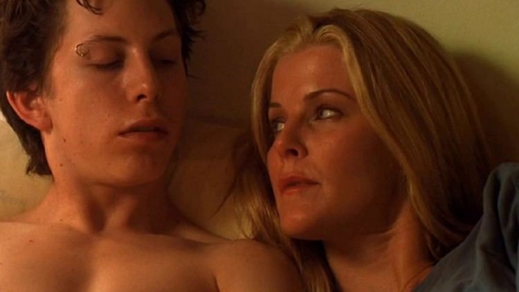 Derek Hamilton and Lori Heuring's intimate scene in a movie scene from Taboo, a 2002 American mystery-thriller film. Derek is topless with a piercing on his right eyebrow while Lori is wearing a gray shirt.