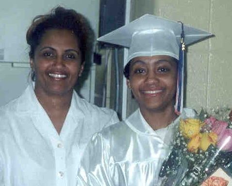 Tamika Huston with her mother, Antonette Huston during her graduation holding a bouquet of flowers.
