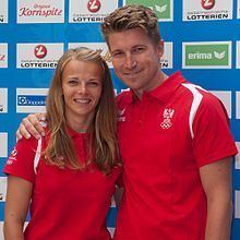 Thomas Zajac and Tanja Frank smiling while wearing a red and white polo shirt