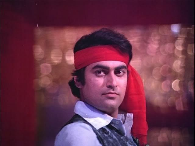 Tariq Khan (actor) wearing a gray and white shirt in a movie scene from "Hum Kisise Kum Nahin (1977)"