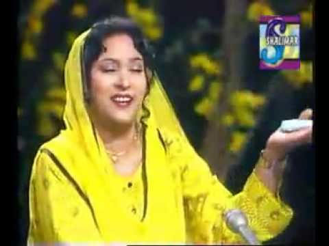 Tassawar Khanum singing on stage and wearing a yellow dress and veil with her eyes closed as featured in a TV Show.