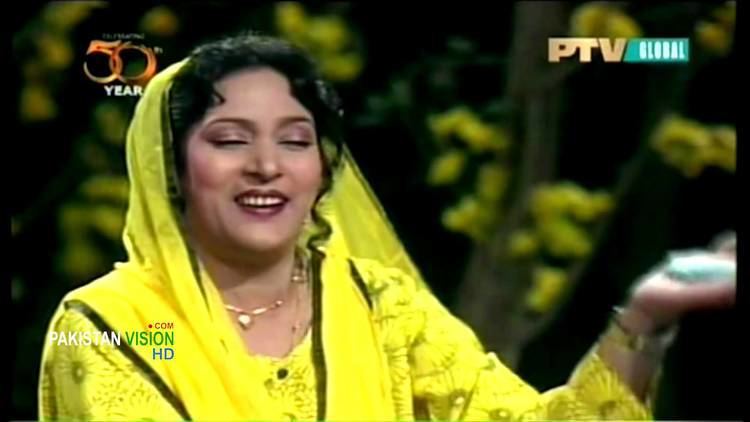Tassawar Khanum singing on stage and wearing a yellow dress and veil with her eyes closed as featured in a TV Show.