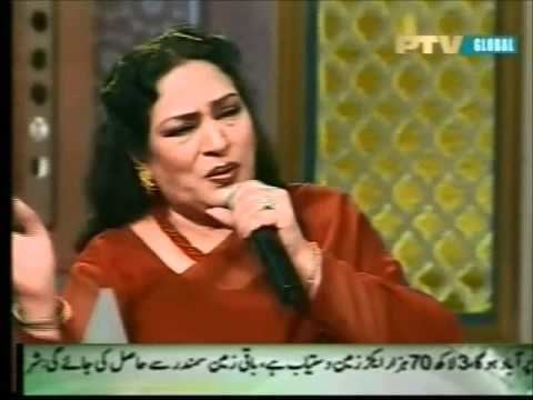Tassawar Khanum singing and wearing a red Indian dress and a red necklace as featured in a TV Show.