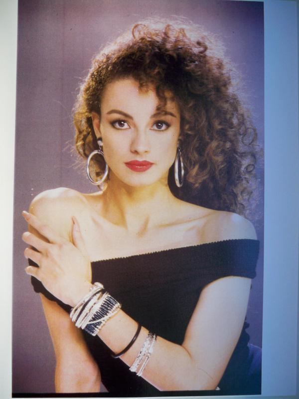 Tatiana Thumbtzen with her curly hair wearing a black off-shoulder shirt, earrings, and bracelets during her pictorial