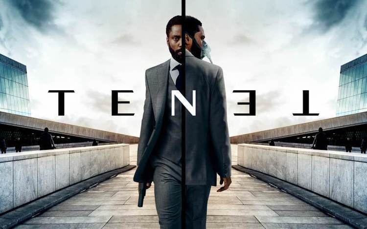 John David Washington holding a gun and wearing a gray suit as he played the role of the protagonist in the 2020 film "Tenet"
